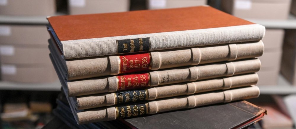 Taufbücher liegen in einem Pfarrarchiv auf einem Tisch