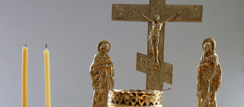 Two blown-out candles in front of an Orthodox cross