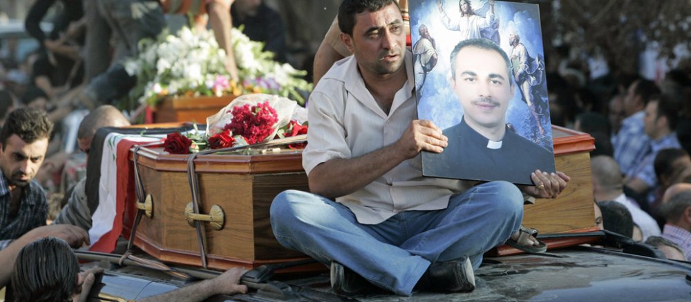 Immer wieder werden Christen im Irak Opfer von Anschlägen. Ein Mann hält ein Bild des Priesters Wassem Sabeeh in den Händen. Sabeeh wurde im November 2010 bei einem Anschlag auf eine Kirche getötet.