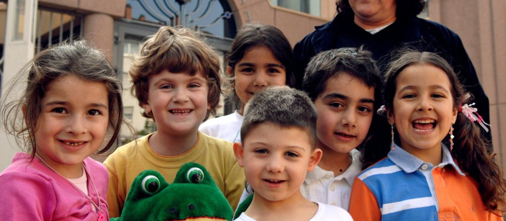 Die Kinder stehen vor einer Moschee.
