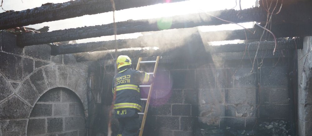 Ein Feuerwehrmann in einem ausgebrannten Haus.