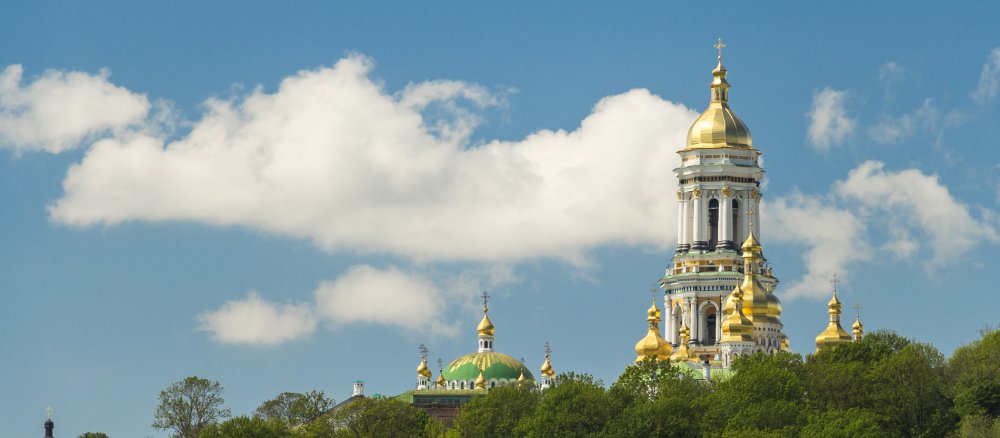 Über dem Dnepr hebt sich das Kiewer Höhlenkloster aus den Bäumen.