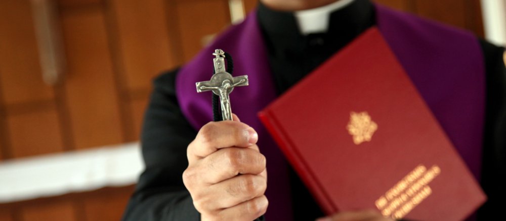 A priest with a cross in his hand.