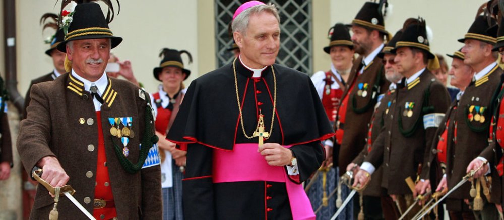 Erzbischof Gänswein mit Männern in bayerischer Trachtenkleidung.