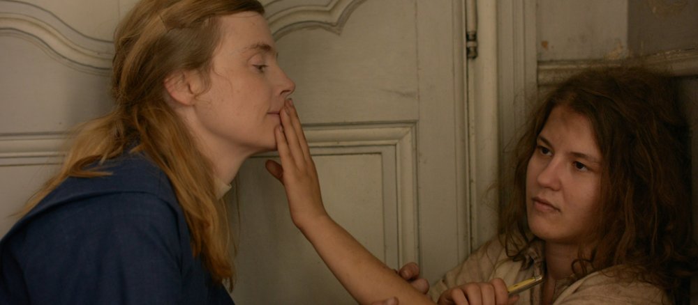 Ein Mädchen hält ihre Hände in das Gesicht einer Nonne.