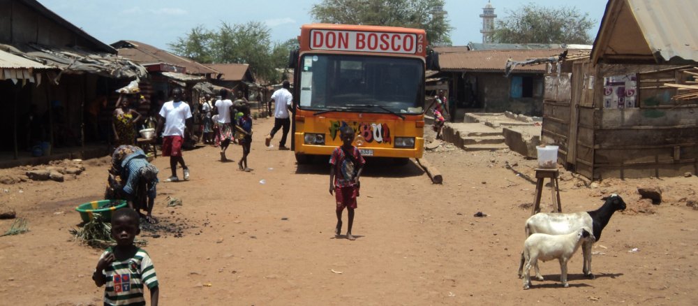 Bus der Don Bosco Mission auf staubiger Dorfstraße.