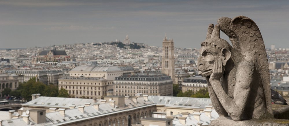 Wasserspeier (Gargoyle) auf der Kathedrale Notre Dame in Paris und die Basilika Sacre Coeur im Hintergrund.