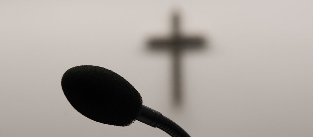Ein Mikrofon vor einem Kreuz