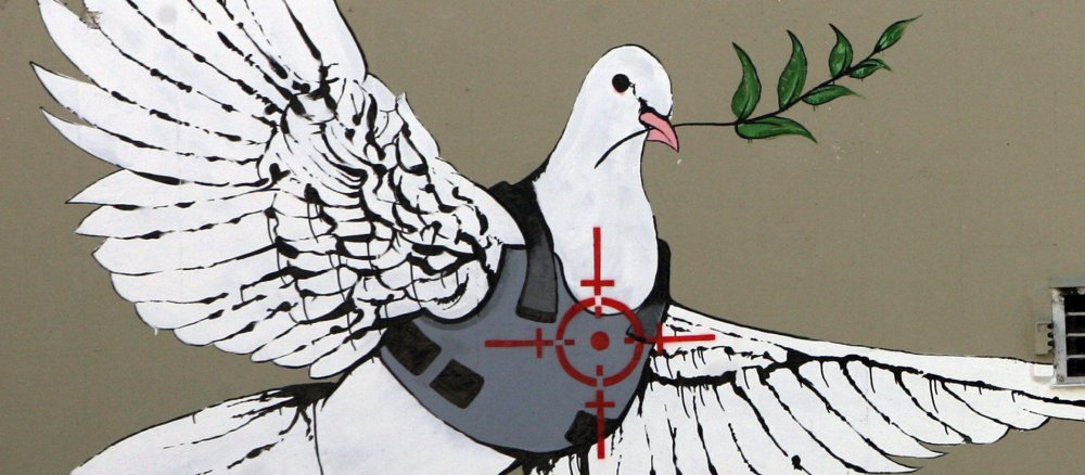 Graffiti einer Friedenstaube mit Schutzweste