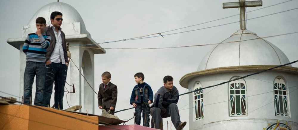 Blicken in eine ungewisse Zukunft: Christen im Irak stehen auf einem Dach vor einer Kirche.