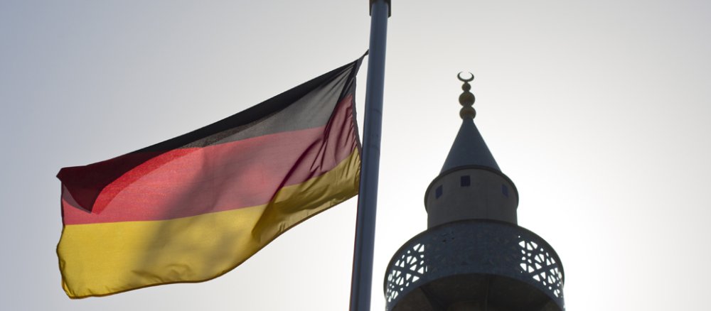 Eine deutsche Flagge neben einem Minarett.