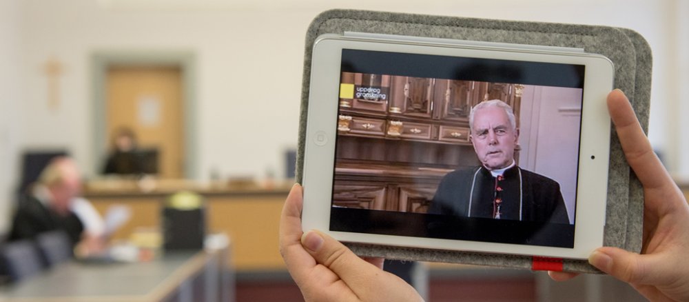 Ein Fernsehteam filmt am 16.01.2013 im Gerichtssaal des Regensburger Amtsgerichts (Bayern) einen Tablet-Computer, auf dem ein Video des Fernsehinterviews mit Holocaust-Leugner Richard Williamson zu sehen ist.