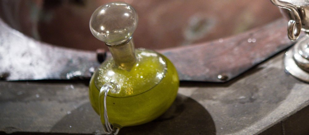 Chrisamöl in einem Glasflakon steht am Rande des Taufbeckens für eine Taufe bereit.