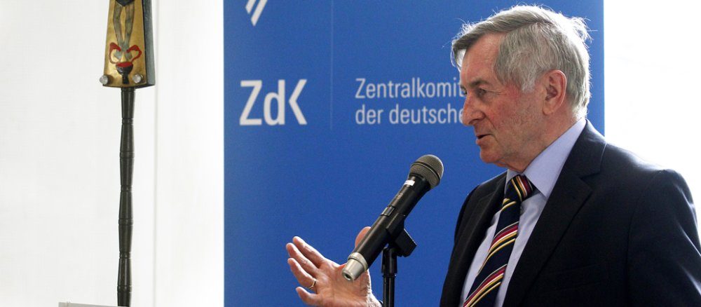 Alois Glück steht spricht vor einer blauen Wand mit dem ZdK-Logo.