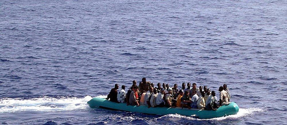 Die Menschen treiben einem kleinen Boot übers Meer.