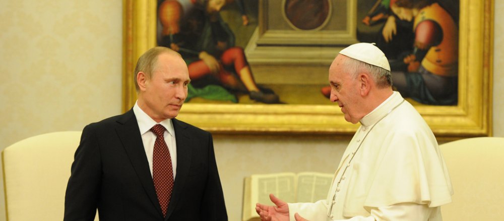 Links steht der russische Staatspräsident, rechts in Weiß der Papst.