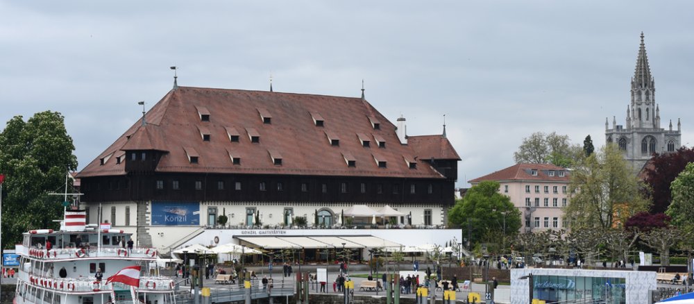 Ein Passagierschiff liegt im Hafen von Konstanz (Baden-Württemberg). Im Hintergrund ist das Konzilsgebäude zu sehen, im Hintergrund das Konstanzer Münster.