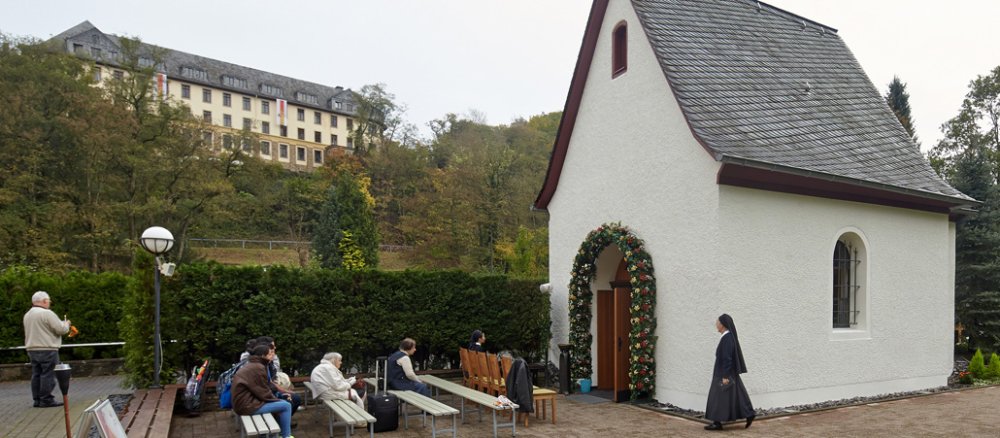 Eine weiße Kapelle mit Besuchern