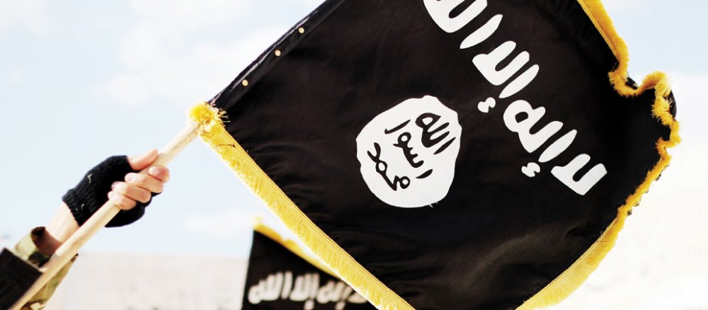 Ein Mann hält in einem Propaganda-Foto des "Islamischen Staats" eine Flagge der Terrormiliz.