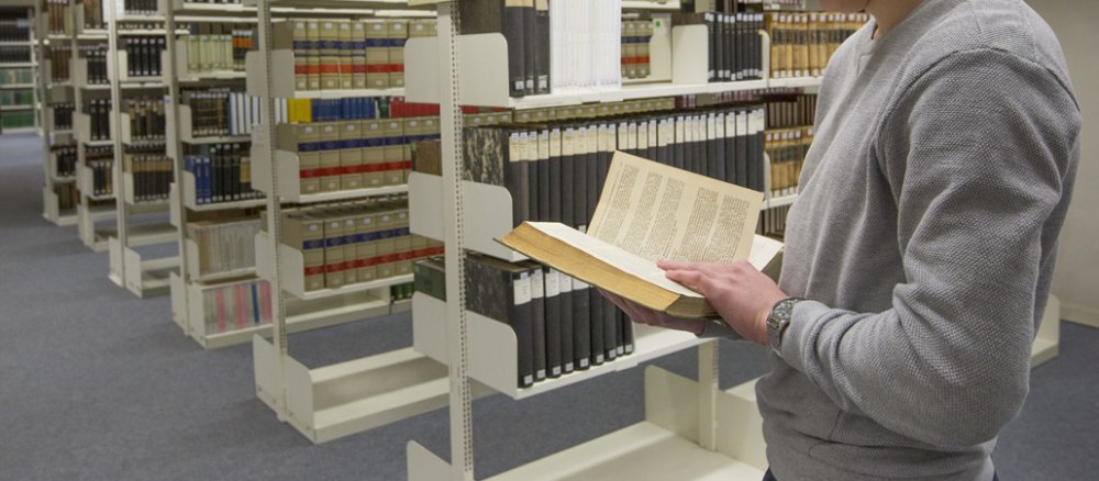 Ein Student liest in der Unibibliothek Osnabrück.