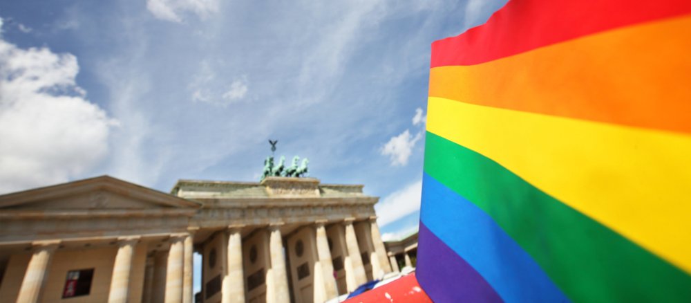 Eine Regenbogenfahne vor dem Berliner Tor.