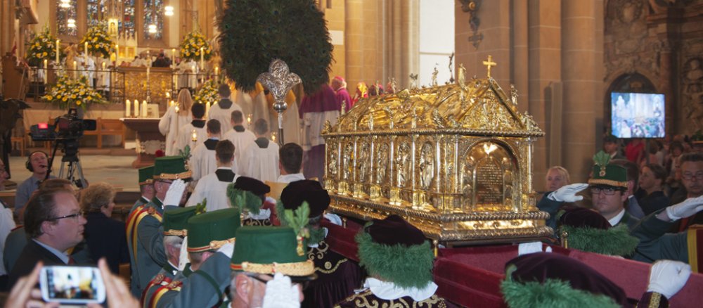 Ein goldener Schrein wird durch den Paderborner Dom getragen.