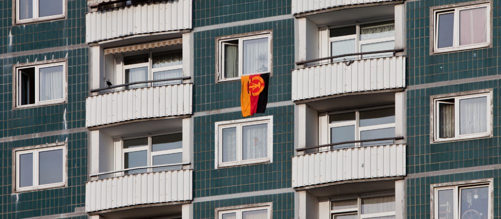 Die Flagge der DDR hängt aus dem Fenster einer Dresdner Wohnung.
