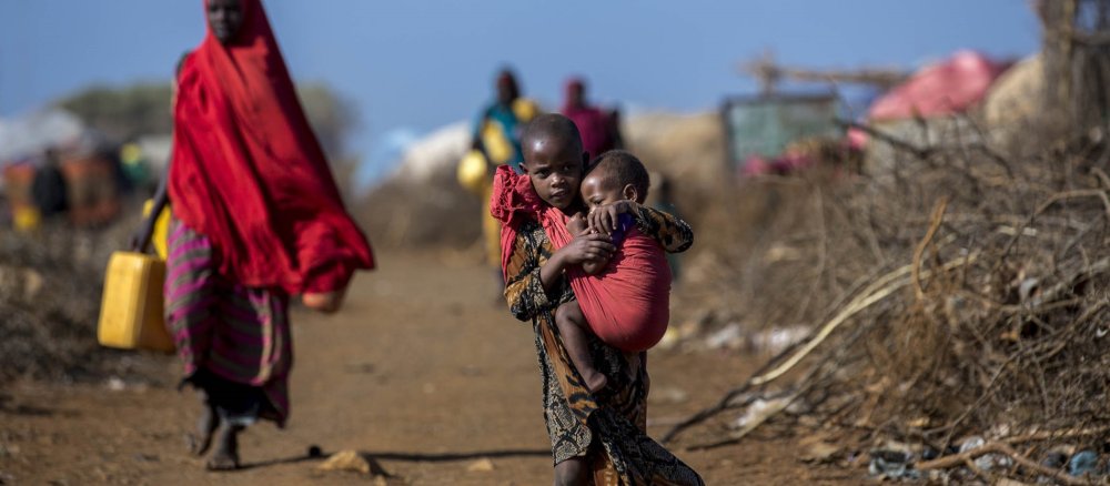 Ein Kind trägt sein Geschwisterchen in einem Flüchtlingslager in Somalia