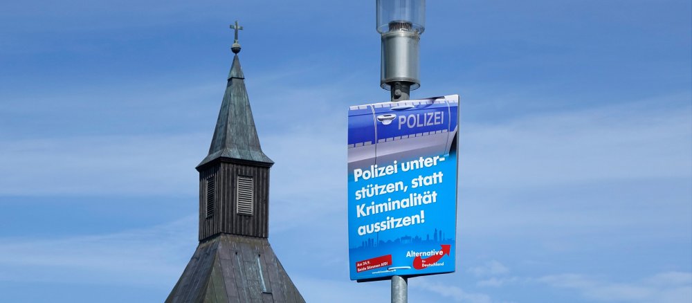 Ein AfD-Plakat vor einer Kirche
