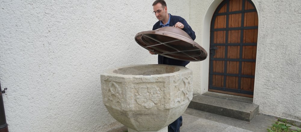 Dem Taufstein von Schloss Lenzburg wird zum Schutz vor Wind und Wetter eine bronzene Haube aufgesetzt.