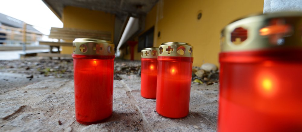 Vier angezündete Grabkerzen stehen am 27.11.2012 in Titisee-Neustadt (Baden-Württemberg) vor einer Behindertenwerkstatt. 14 Menschen sind bei einem Brand in der Einrichtung am 26.11.2012 ums Leben gekommen.
