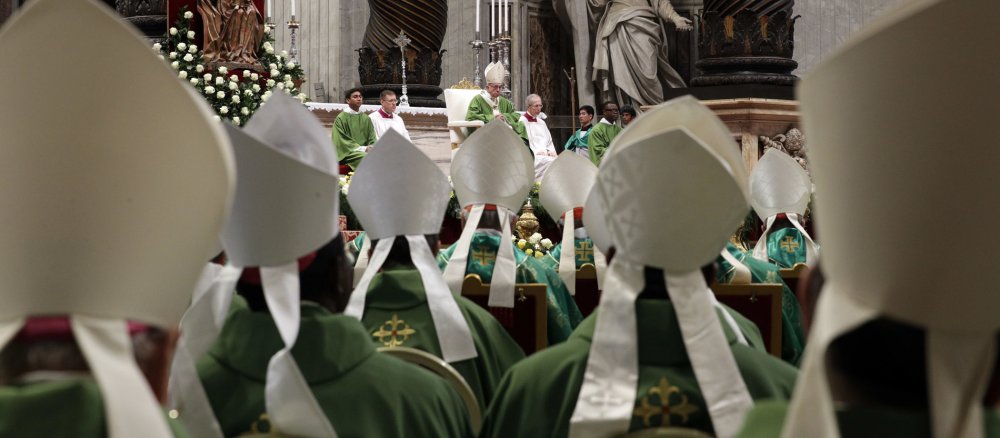 Blick auf Papst Franziskus über Bischofskappen hinweg