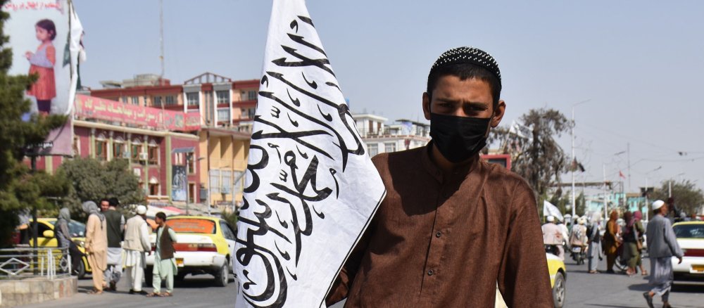 Ein junger Taliban mit Flagge in der Hand