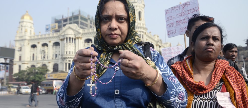 An Indian Christian woman holds a rosary in her hand.