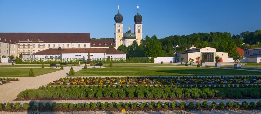 Ein Kloster samt Kirche liegt in einem Garten.