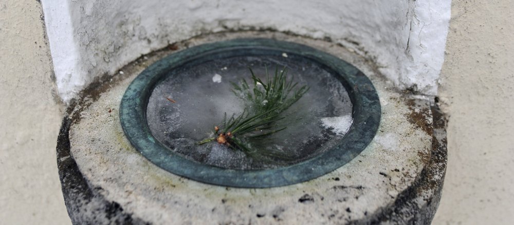 Gefrohrenes Weihwasser mit einem Tannenzweig drin.
