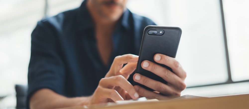 Ein Mann tippt auf seinem Smartphone