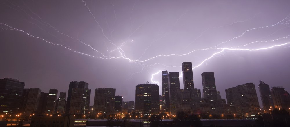 Ein Gewitter entlädt sich über der Skyline von Peking.