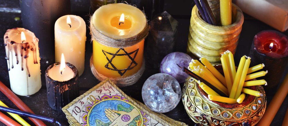 Stillleben mit brennenden Kerzen, Edelsteinen und Tarot-Karten