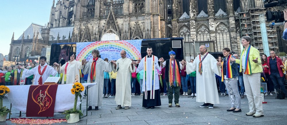 Priester und Seelsorgerinnen feiern einen Segnungsgottesdienst vor dem Kölner Dom