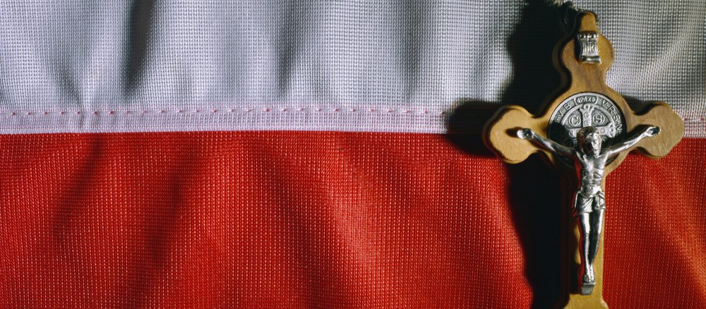 Ein Kruzifix liegt auf einer polnischen Flagge