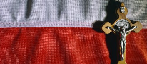 Ein Kruzifix liegt auf einer polnischen Flagge