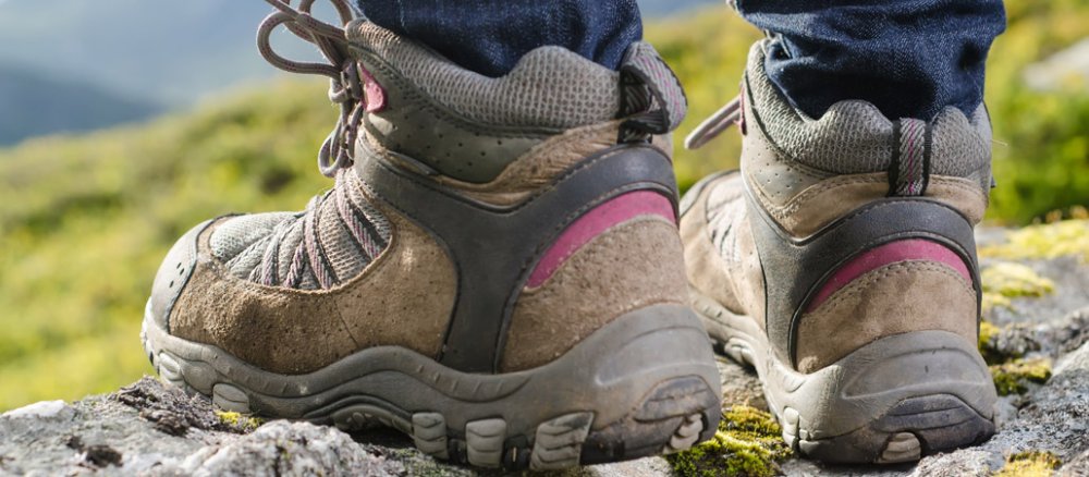 Pilger steht auf Felsen, man sieht nur die Wanderschuhe in Großaufnahme