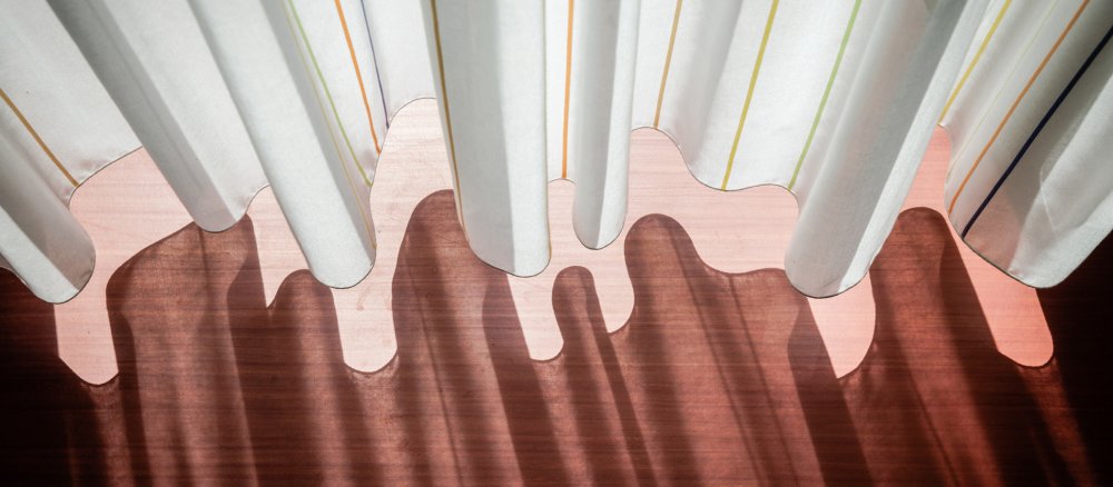 Ein Vorhang wirft Schatten auf den Boden