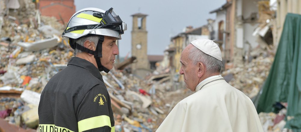 Papst Franziskus, bei seinem Überraschungsbesuch, mit einem Feuerwehrmann vor den Trümmern des vom Erdbeben zerstörten Amatrice am 4. Oktober 2016.