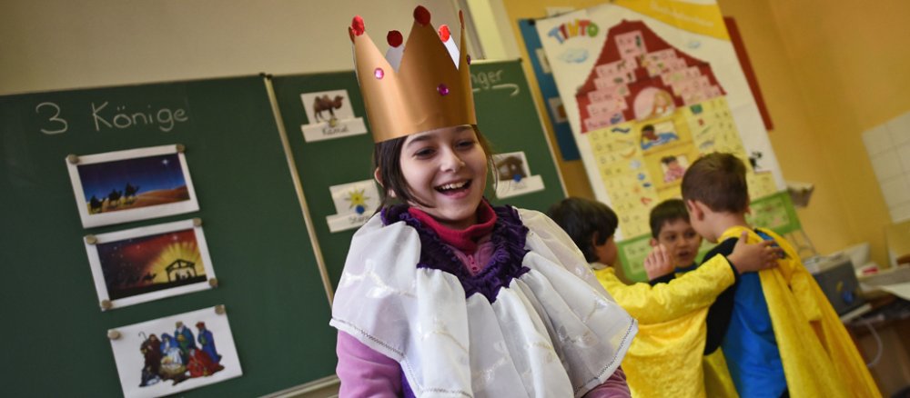 Die Schülerin Meriem (10 Jahre) aus Serbien probiert am 14.12.2015 in der Sternsinger-Grundschule in Köln (Nordrhein-Westfalen) ein Sternsinger-Kostüm an.