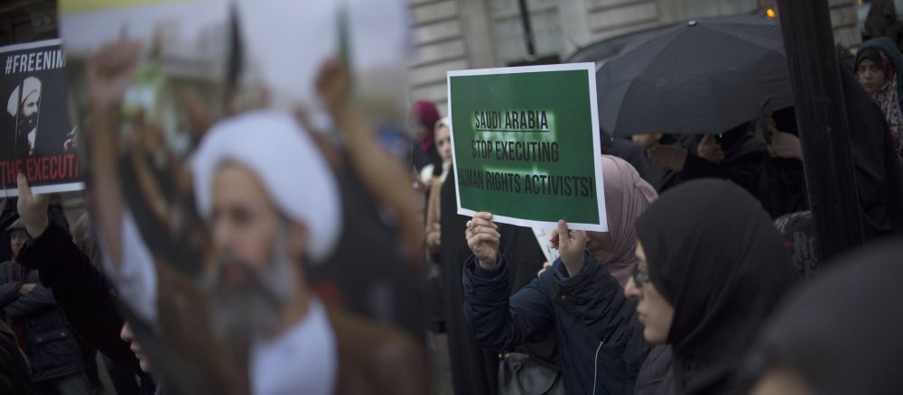 Demonstranten halten Plakate in die Luft.