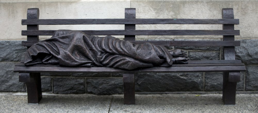 Eine Skulptur zeigt den obdachlosen Jesus auf einer Bank