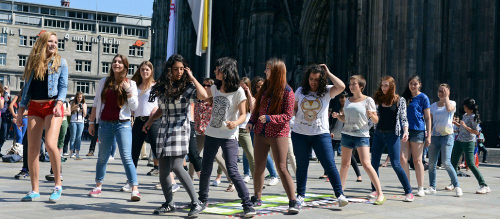 Jugendliche Tanzen während des Eucharistischen Kongresses vor dem Kölner Dom.