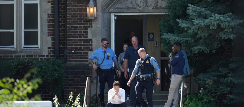Der Bürgermeister von Minneapolis, Jacob Frey, sitzt auf den Stufen der Schule der Annunciation Church, während die Polizei auf einen gemeldeten Amoklauf reagiert.